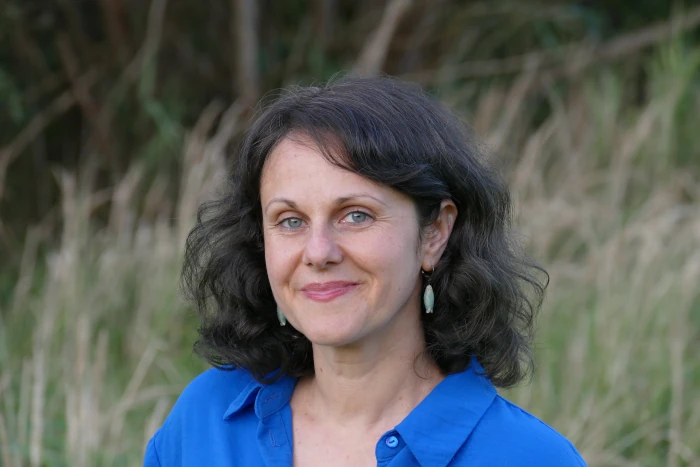 A profile image of Sanja Cekov - dramatherapist, systemic coach & supervisor, taken in the natural surrounding.